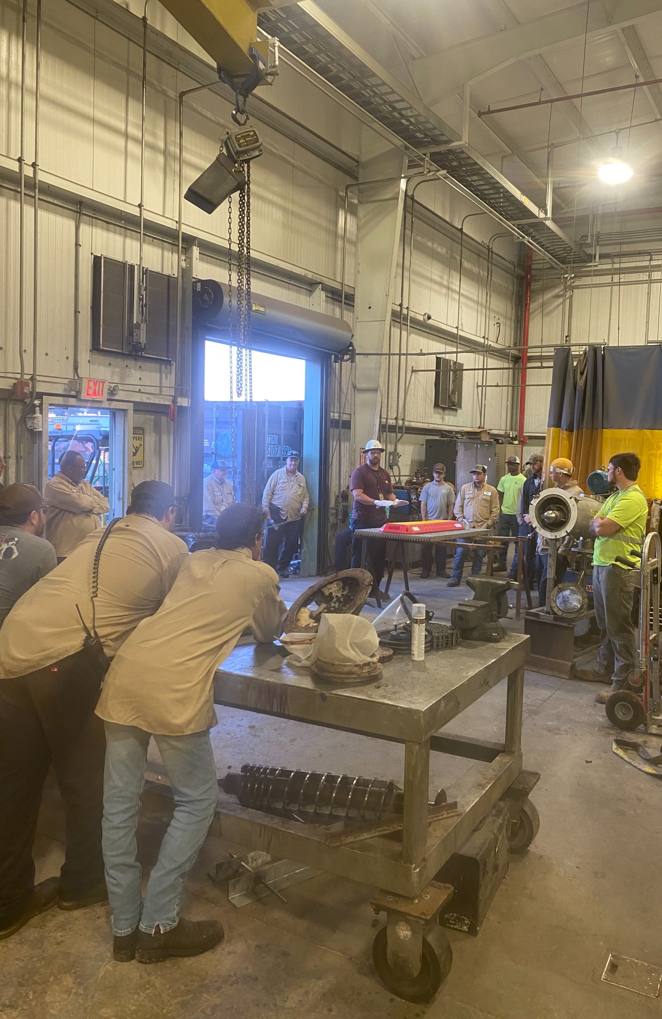 Team members gathered for hands-on instruction in the shop